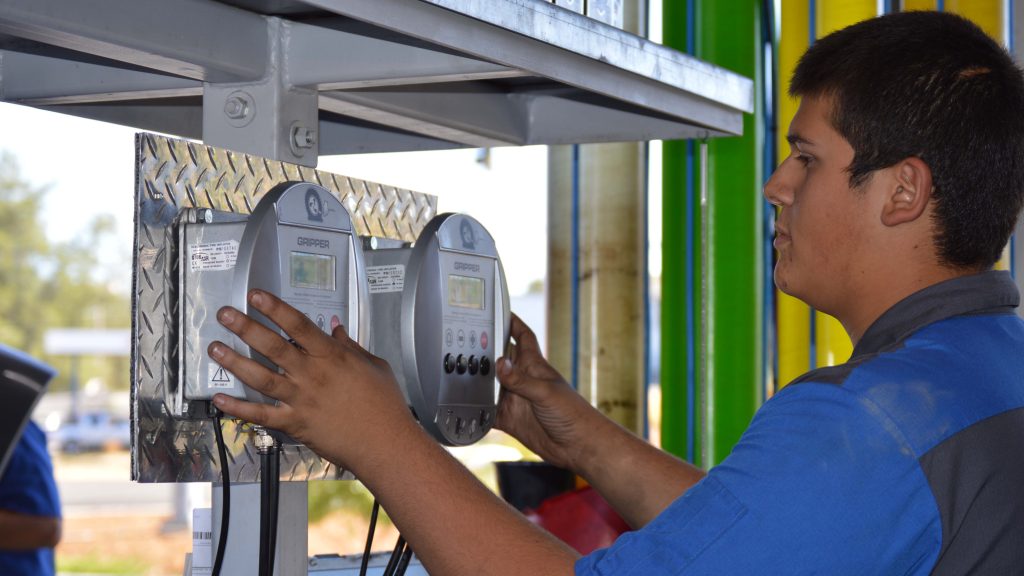 A worker using the Gripper Tire Inflator in a garage